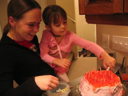Jolene and Maddy putting candles on the cake