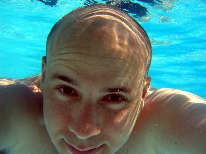 Yours truly grinning in the bright blue pool water